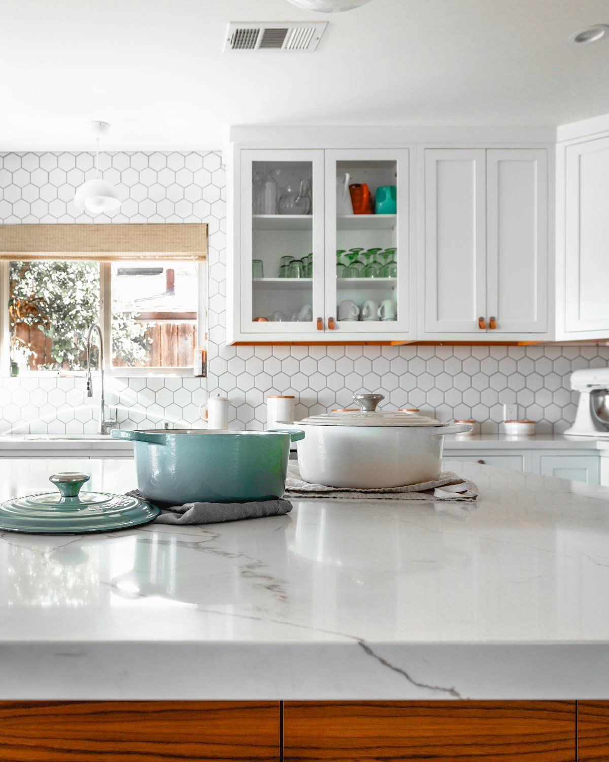 Bright modern Toronto kitchen featuring a Calacatta-style quartz countertop with subtle veining, white cabinetry and a hexagonal tile backsplash.