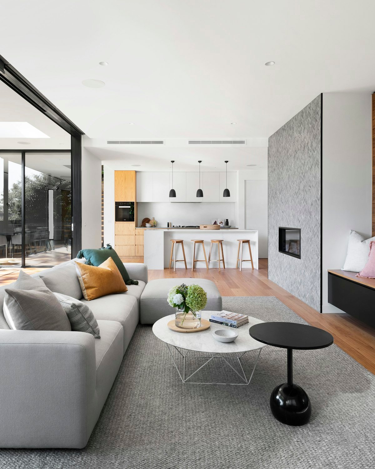 Open-plan modern condo kitchen with a quartz waterfall island and pendant lighting
